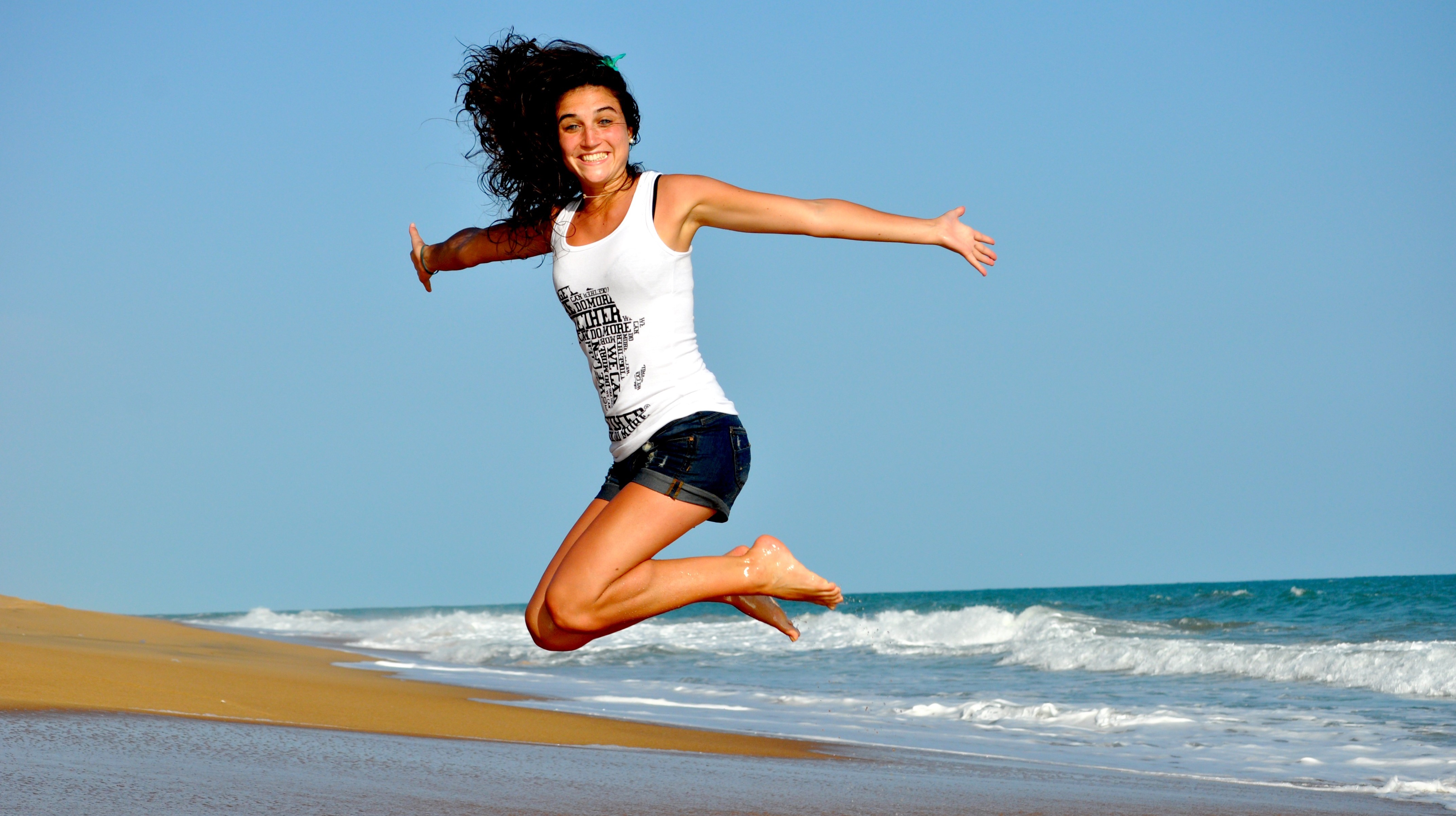 Femme heureuse sautant sur la plage, hygiène de vie, consultation de naturopathie, naturopathe rennes